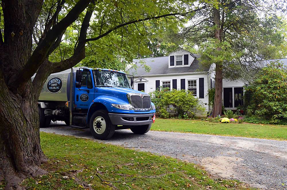 A Chester County Fuel Oil truck parked outside a customer's home