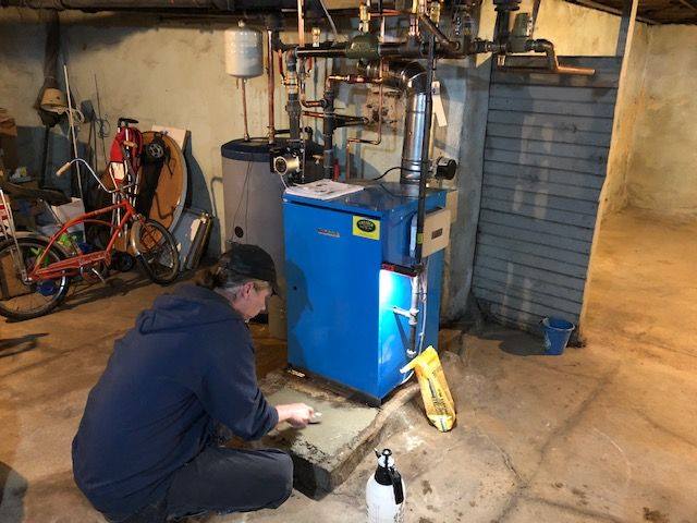 A Chester County Fuel Oil technician providing seasonal HVAC maintenance for an oil furnace