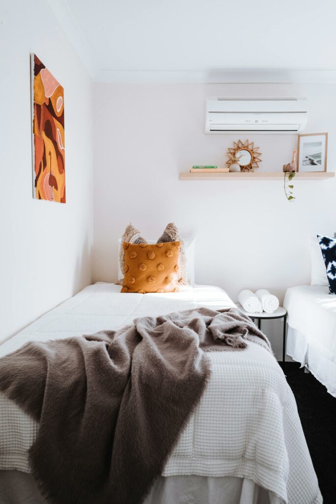 A bedrom with a minisplit heat pump operated by a smart thermostat